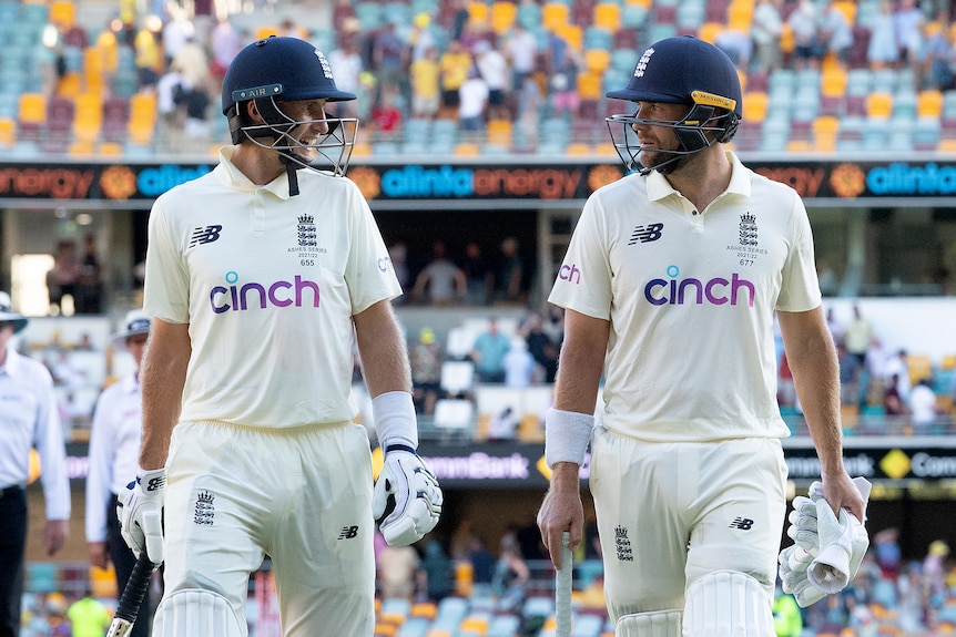 Englishmen Joe Root and Dawid Malan leave the field at stumps on day 3 of the First Ashes Test