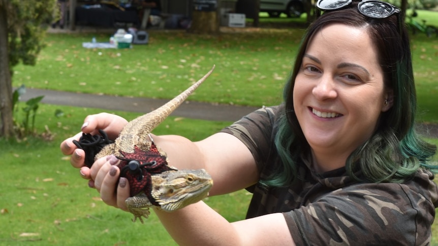 Woman holds a beaded dragon.