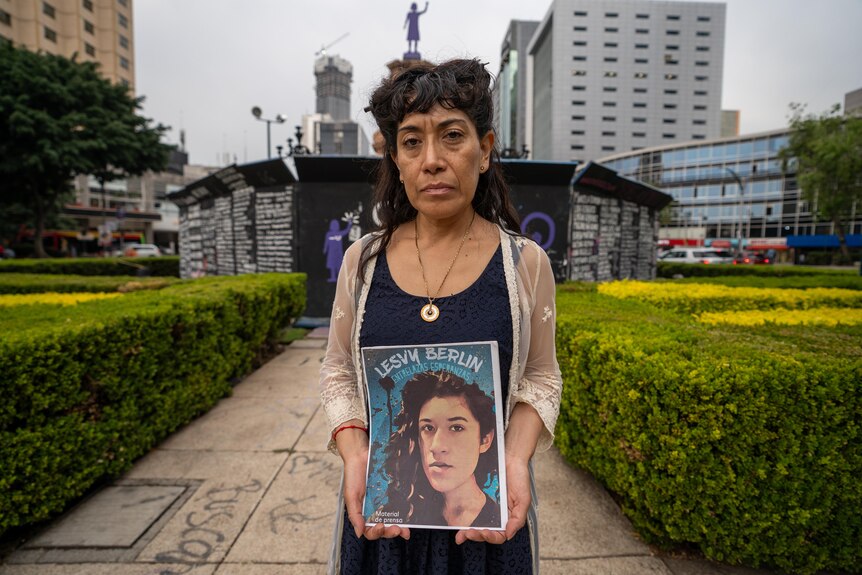 Araceli Osorio holds a photo of daughter at the monument to women in Mexico.