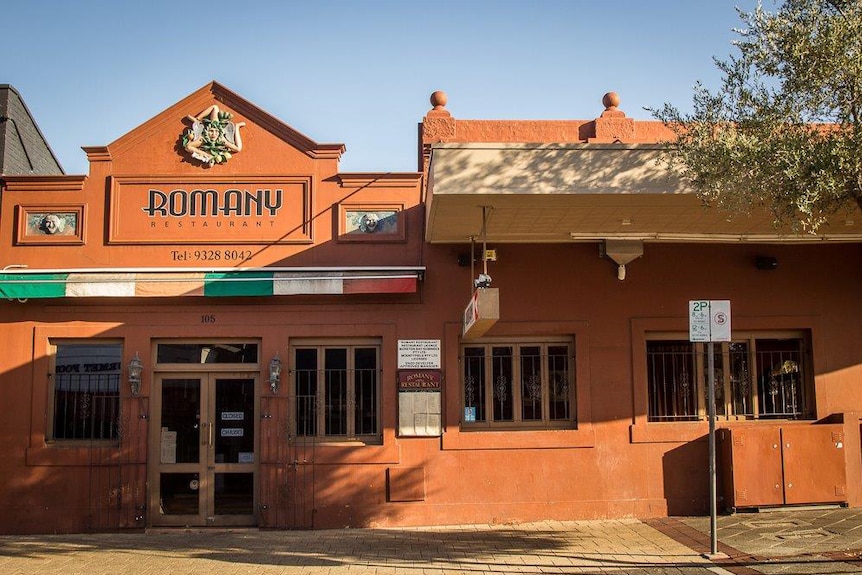 An exterior shot of Romany Restaurant in Northbridge, showing its terracotta walls and front doors under a blue sky.