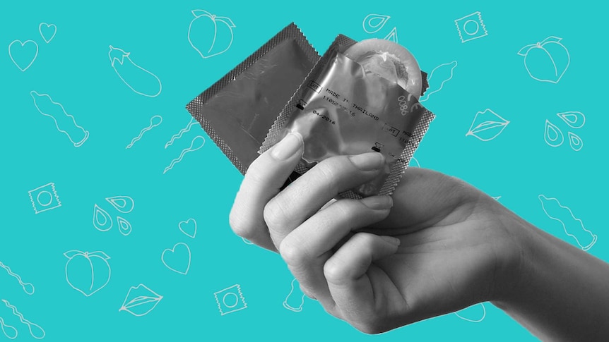 A hand holding up two condoms against a red background covered in drawn peaches, eggplants, hearts and condoms.