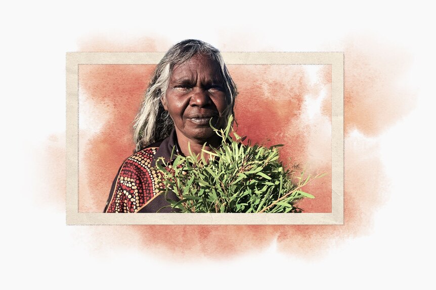 an aboriginal woman carrying leaves