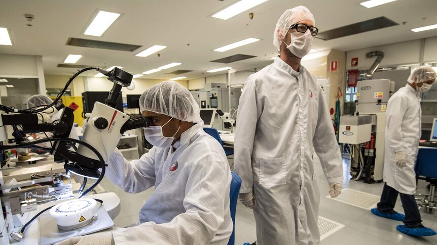 Scientists working around in the Australian National Fabrication Facility at UNSW, where quantum chips are created.