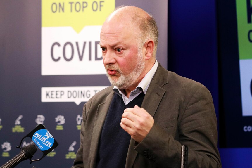 Tasmania's director of Public Health Mark Veitch gesturing during a press conference.