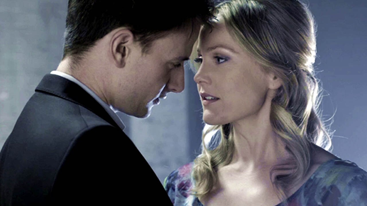 Man and woman embrace with heads touching and look into each others eyes