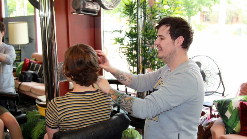 A hairdresser chats discusses the haircut plan with his client