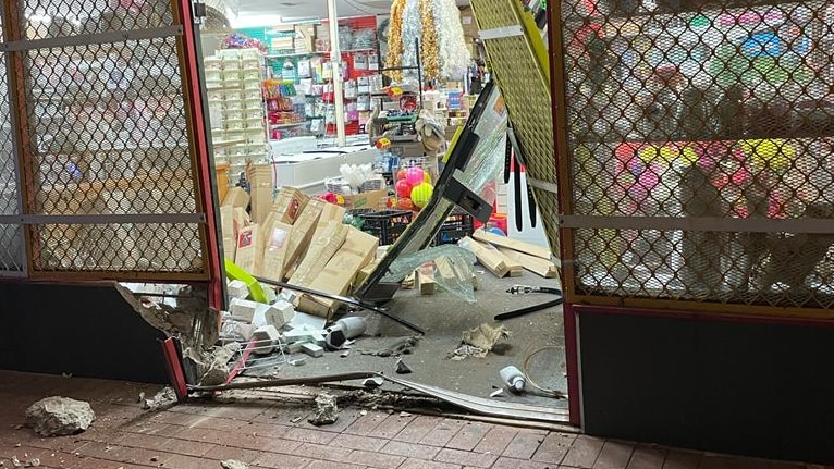 shop front door smashed in surrounded by debris