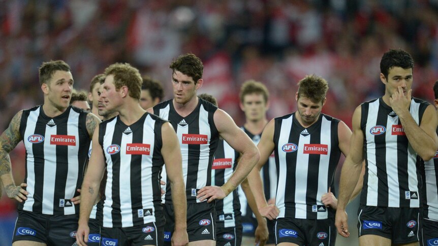 Collingwood players walk off the ground after losing the preliminary final to Sydney.