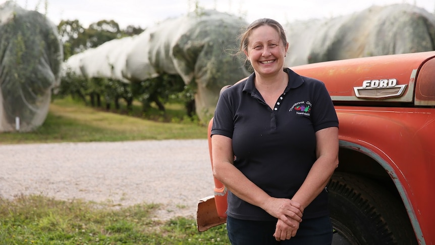 Paul Charnock standing in front of her orchard