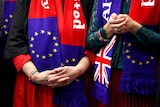 Close up of two women, hands clasped, wearing EU and UK flag scarves