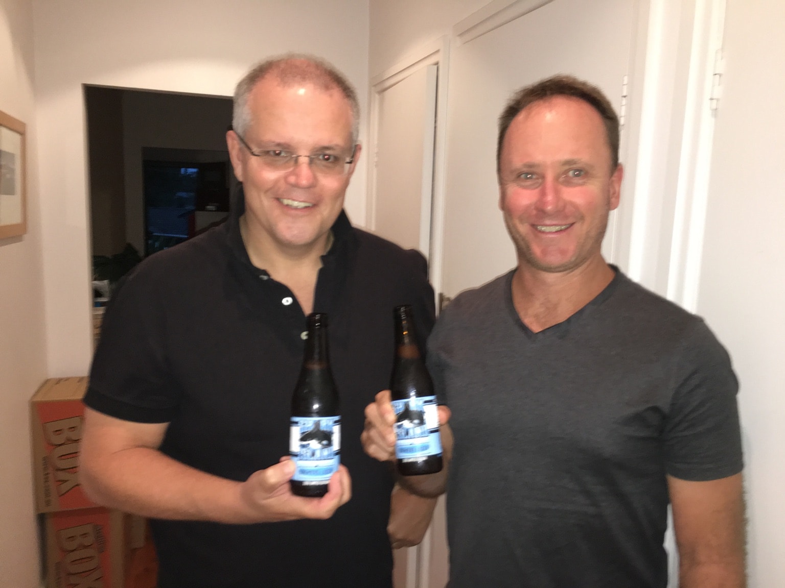 Scott Morrison and Tim Stewart smile and hold beers.