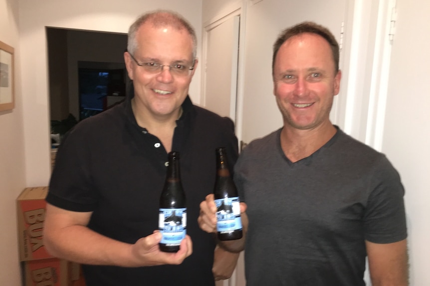 Scott Morrison and Tim Stewart smile and hold beers.