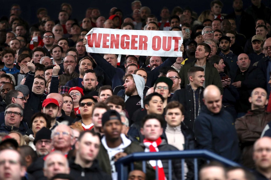 A fan holds up a banner, during a Premier League match between West Brom and Arsenal in 2017.