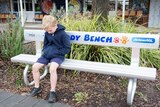 Child sitting on buddy bench