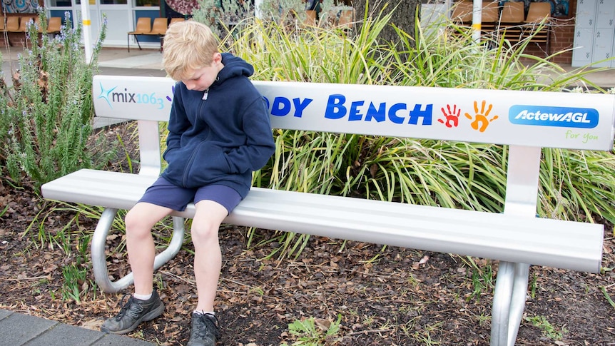 Child sitting on buddy bench