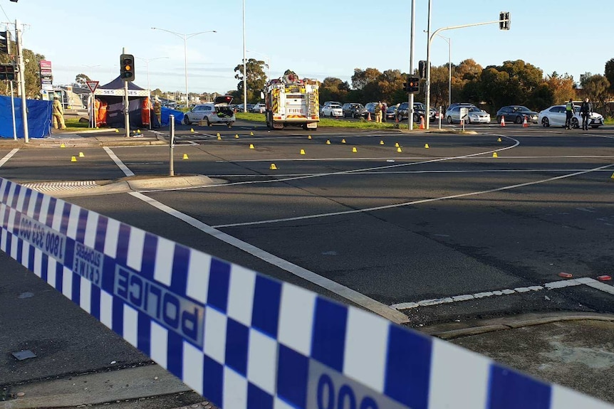 An SES tent is set up next to a large intersection behind police tape.