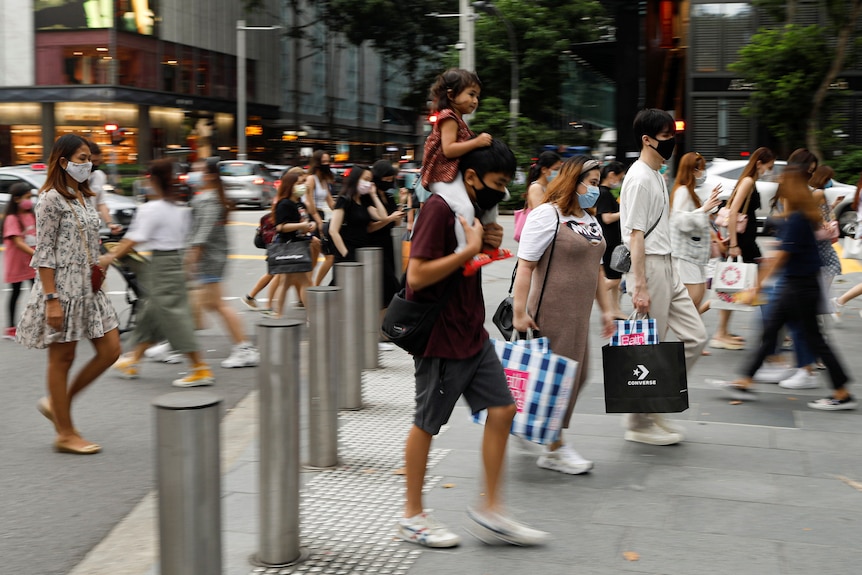 People walk on a street in Singapore