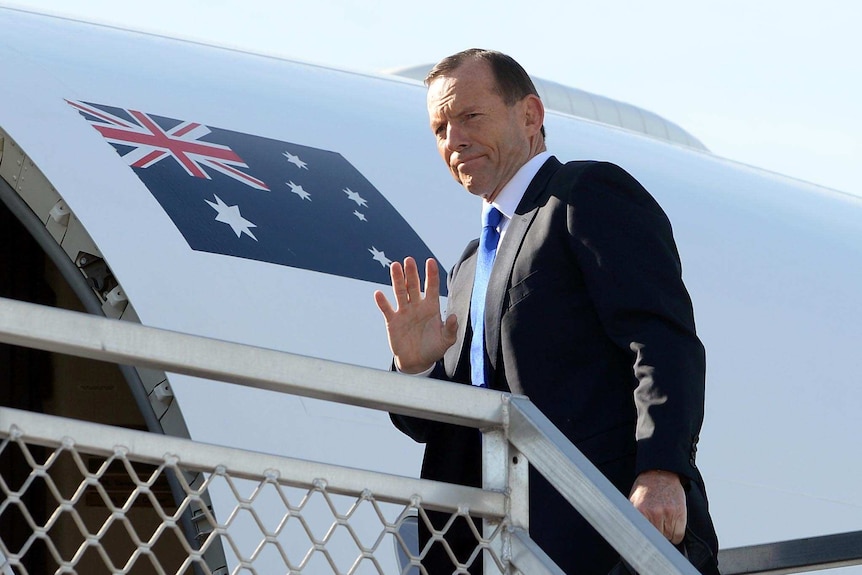 Prime Minister Tony Abbott boards an RAAF jet in Sydney before departing for Indonesia.