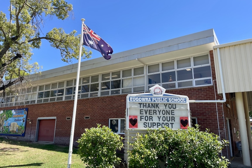 A sign outside a school building next to an Australian flag. It says: Thankyou everyone for your support.