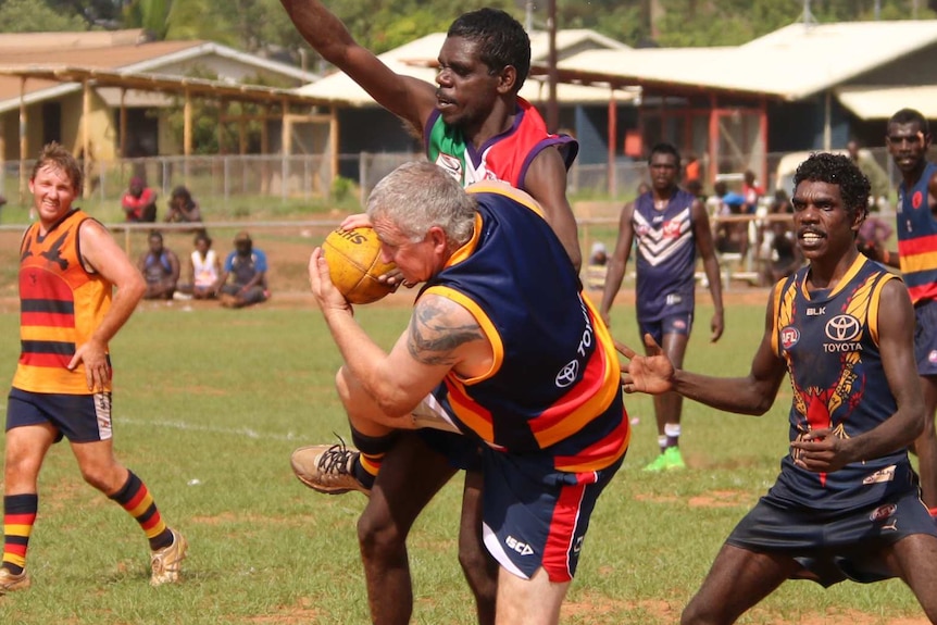 NT Police sergeant Scott Rose for the Crows takes a mark at the 2015 Wadeye Grand Final.