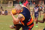 NT Police sergeant Scott Rose for the Crows takes a mark at the 2015 Wadeye Grand Final.