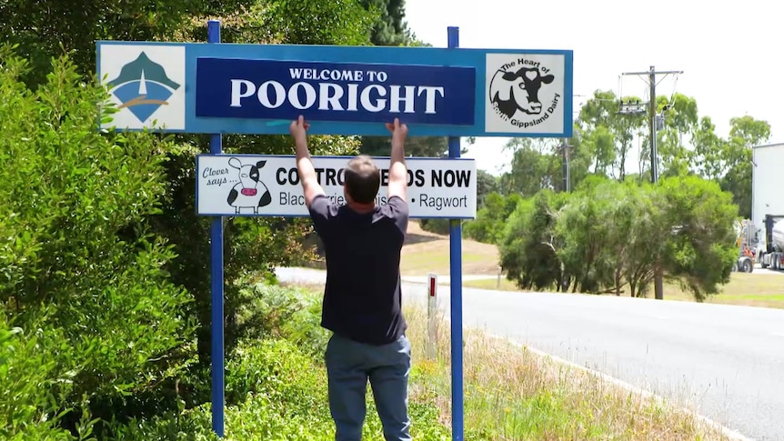 A man puts a sign up that says Pooright.