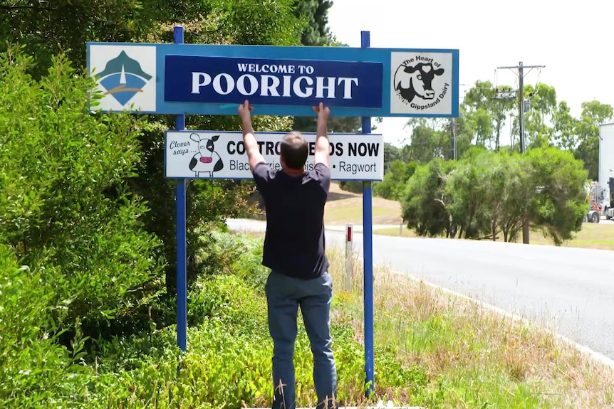 A man puts a sign up that says Pooright.