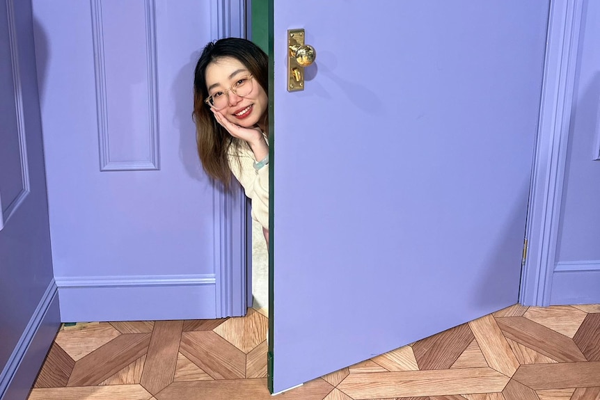 a woman poses for pictures with a purple door
