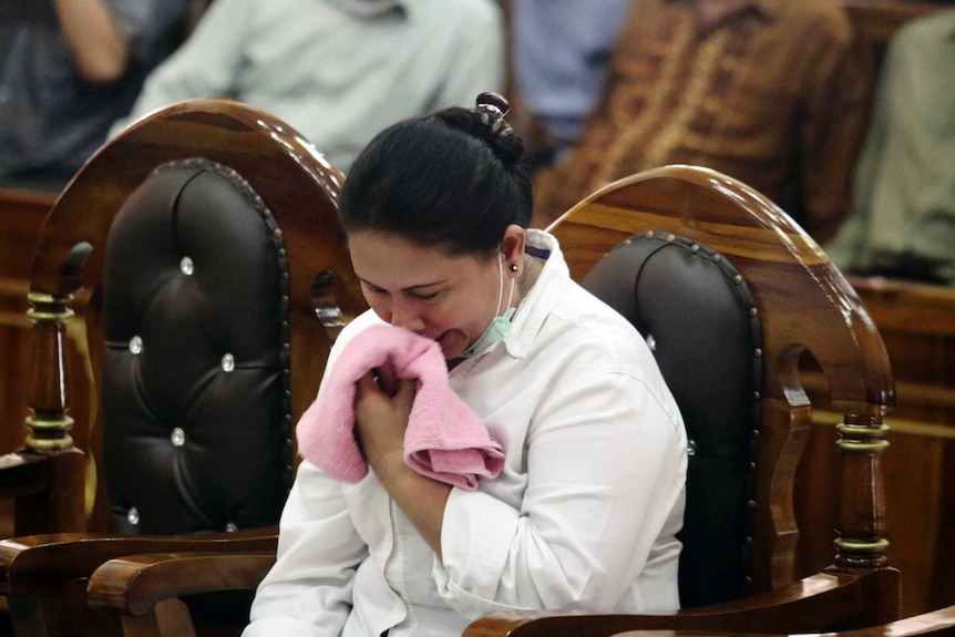 Seorang perempuan duduk menangis di pengadilan