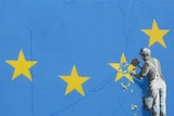 The piece shows a workman up a ladder chipping away to remove a star on the EU flag.