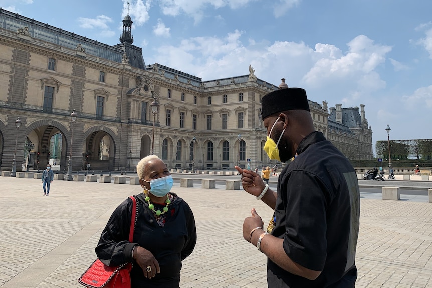 Mwazulu Diyabanza speaks with a woman outside the Louvre.