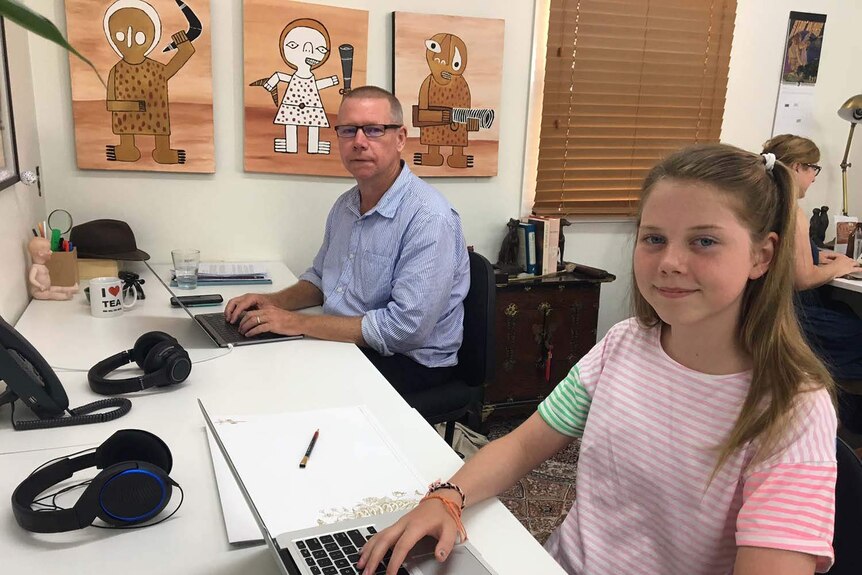 Jeff Smith with his 12-year-old daughter Arkie sitting at computers in their house in Brisbane in January 2018.