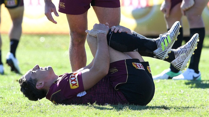 Billy Slater grimaces after rolling his ankle during Queensland State of Origin training.