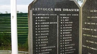 A stone memorial in a garden with names of people killed in a bus crash.