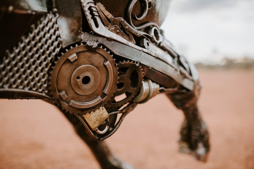 A close-up of the detail on a metal sculpture of tools and scrap steel that make up a bullock.