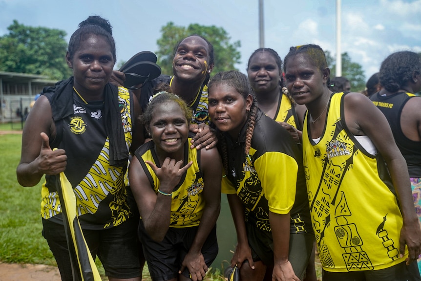 A group of female Imalu Tigers fans stand together near the field at the Tiwi Islands grand final.