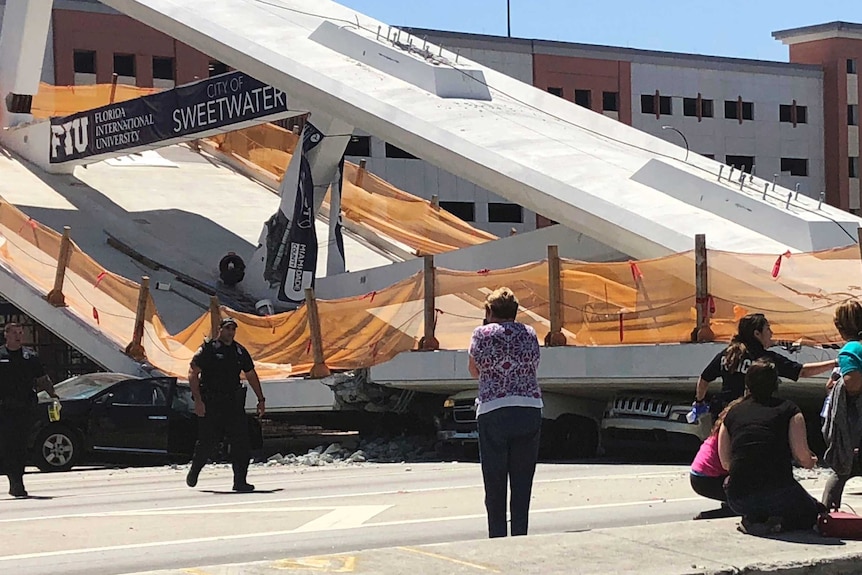 A close-up image of cars crushed beneath the collapsed bridge.