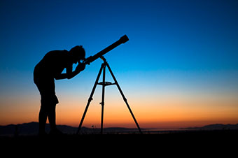 The silhouette of a man and a telescope.