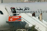 An Afriqiyah Airways plane stands on the tarmac at Malta International airport as passengers depart