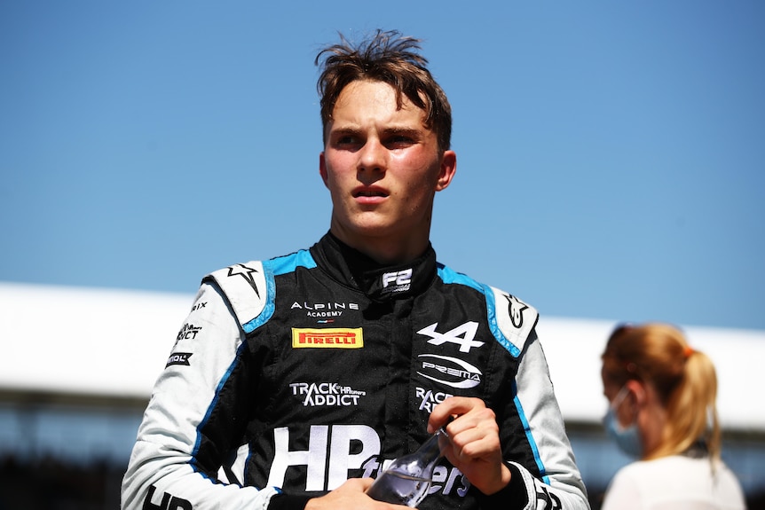 Racing driver with his helmet off holding a water bottle