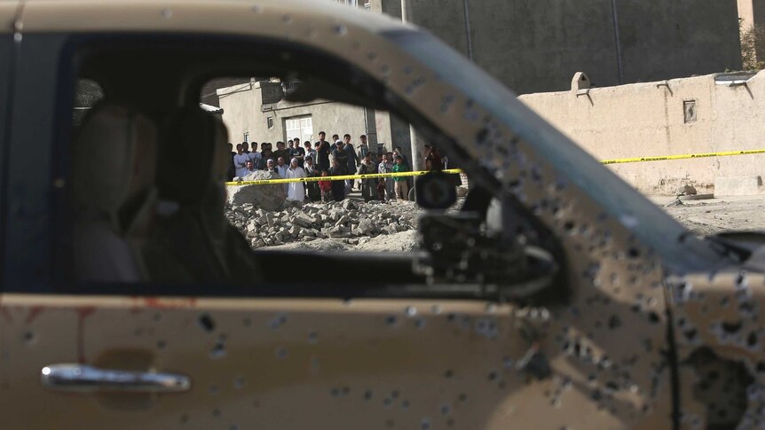 Car with bullet holes, and people can be seen through the window