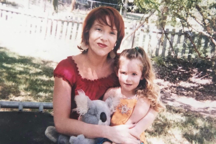 A woman and a little girl with a teddy sit together