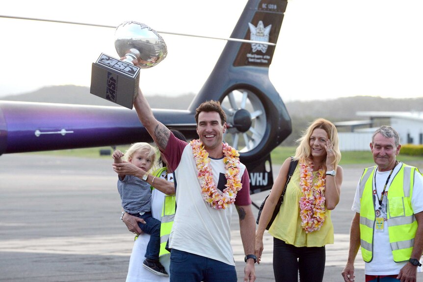 Joel Parkinson shows off his world surfing title gong to fans at Gold Coast Airport.