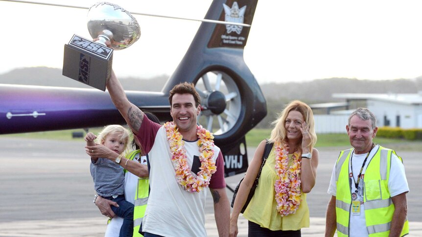 Joel Parkinson shows the world title trophy to fans at Gold Coast Airport.