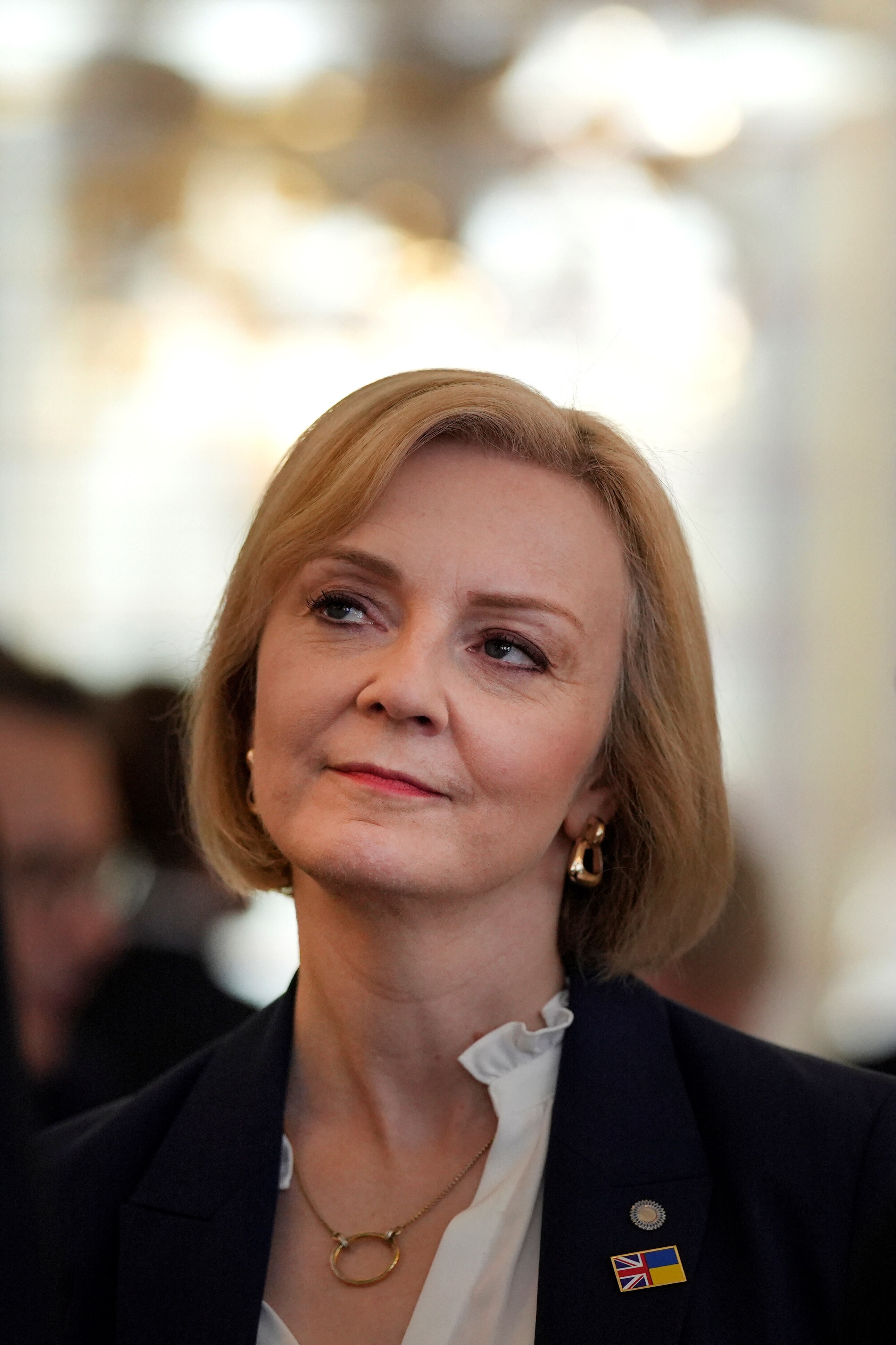 Η Λιζ Τρας κοιτάζει στοχαστικά στη μια πλευρά