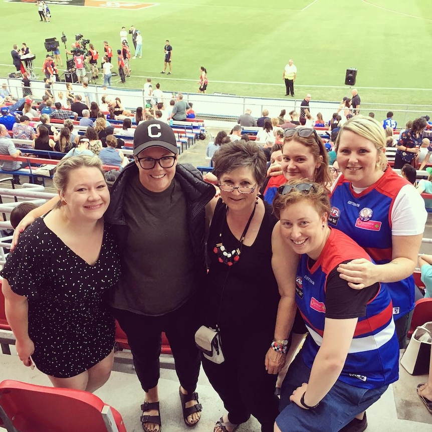 Kate O'Halloran (bottom right) meets with coach Bec Goddard at an AFLW game.