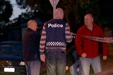 Police stand outside a house in Melbourne after 19 search warrants were executed this week.