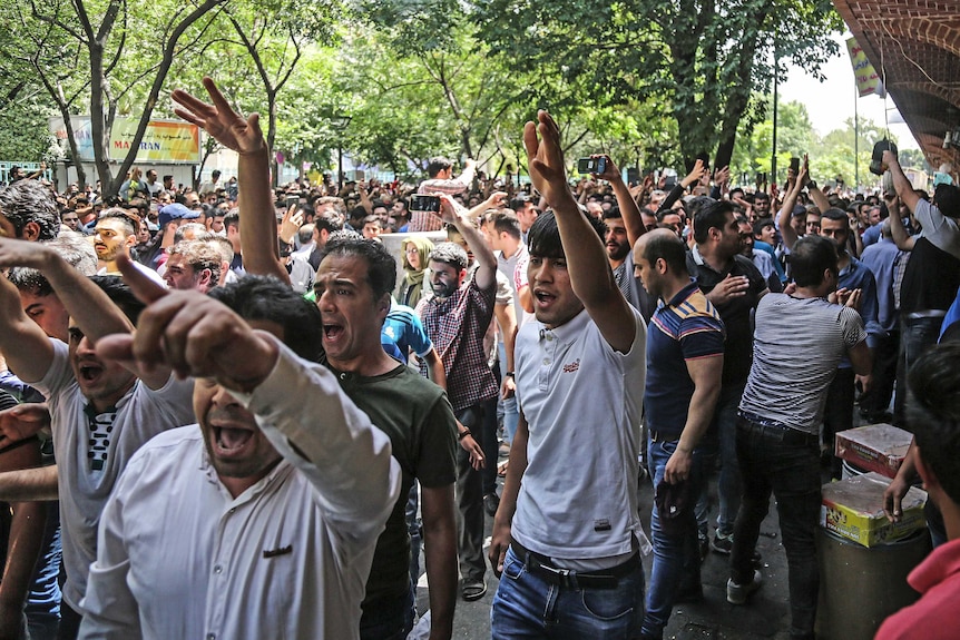 Hundreds of Iranian men march in the streets over the country's economic crisis