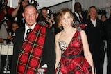 30-something white man with close-shaved head wearing suit and tartan sash with 30-something white woman in tartan dress.