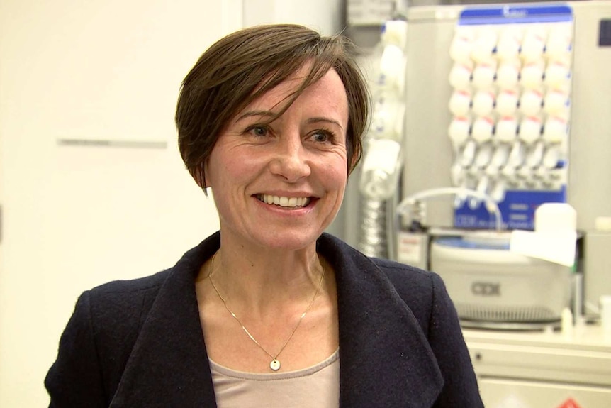 A woman in a lab smiling.